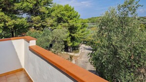 A balcony with a view of a garden and trees.
