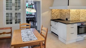 Une cuisine de taille réduite avec des meubles blancs, un plan de travail noir et un four encastré.