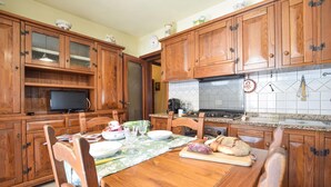 Una cocina de madera con una mesa de comedor, sillas y armarios.
