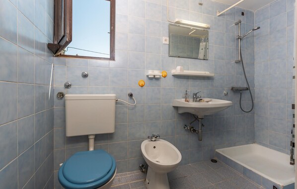 Un baño con inodoro, bidé, lavabo y bañera.