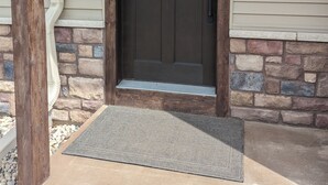 A dark brown front door with a small window above it, set in a beige house with stone accents. - Appleton Country home with AC and Wifi (Appleton)