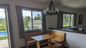 A room with a wooden bench and table, large windows, and a chandelier. - Appleton Country home with AC and Wifi (Appleton)