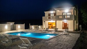 A modern two-story house with a swimming pool and lounge chairs. - Lovely home in Posedarje (Posedarje)