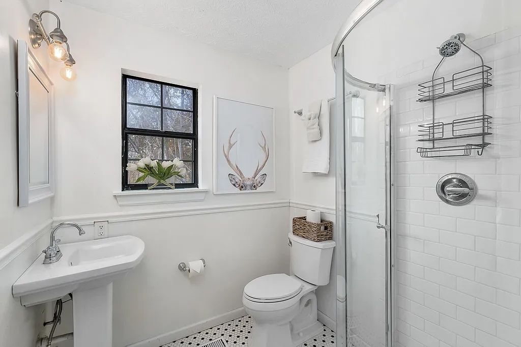A bathroom with a sink, toilet, and shower.