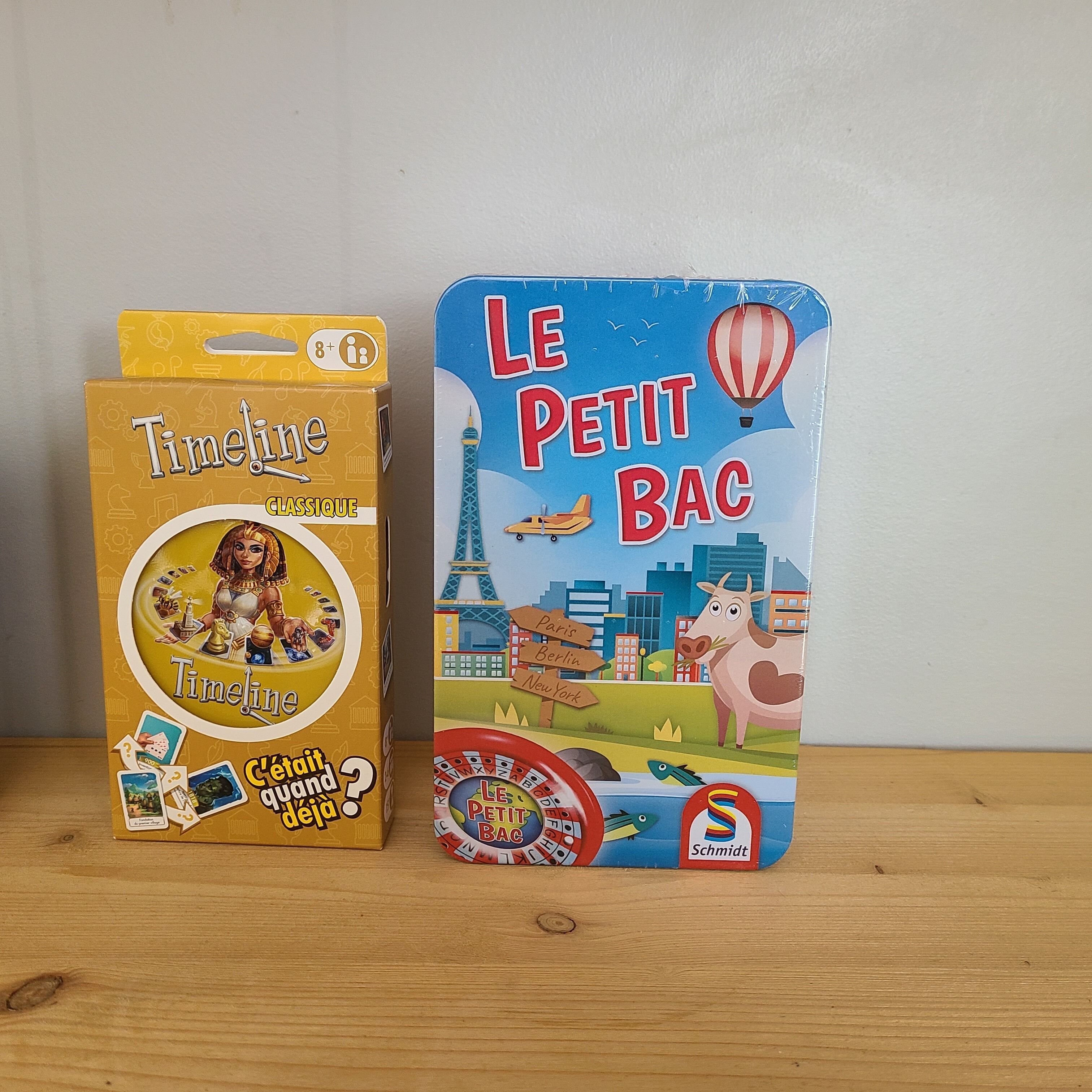 Due giochi da tavolo, 'Timeline' e 'Le Petit Bac', su un piano di legno.