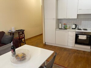 A compact kitchen with white cabinets, a small dining table, a coffee machine, and a kettle. - Suites in Rome 2 - Appartament (Rome)