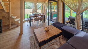 A wooden interior with a dining area, a sofa, and a staircase. - Nice home in Nowe Warpno with sauna (Nowe Warpno)