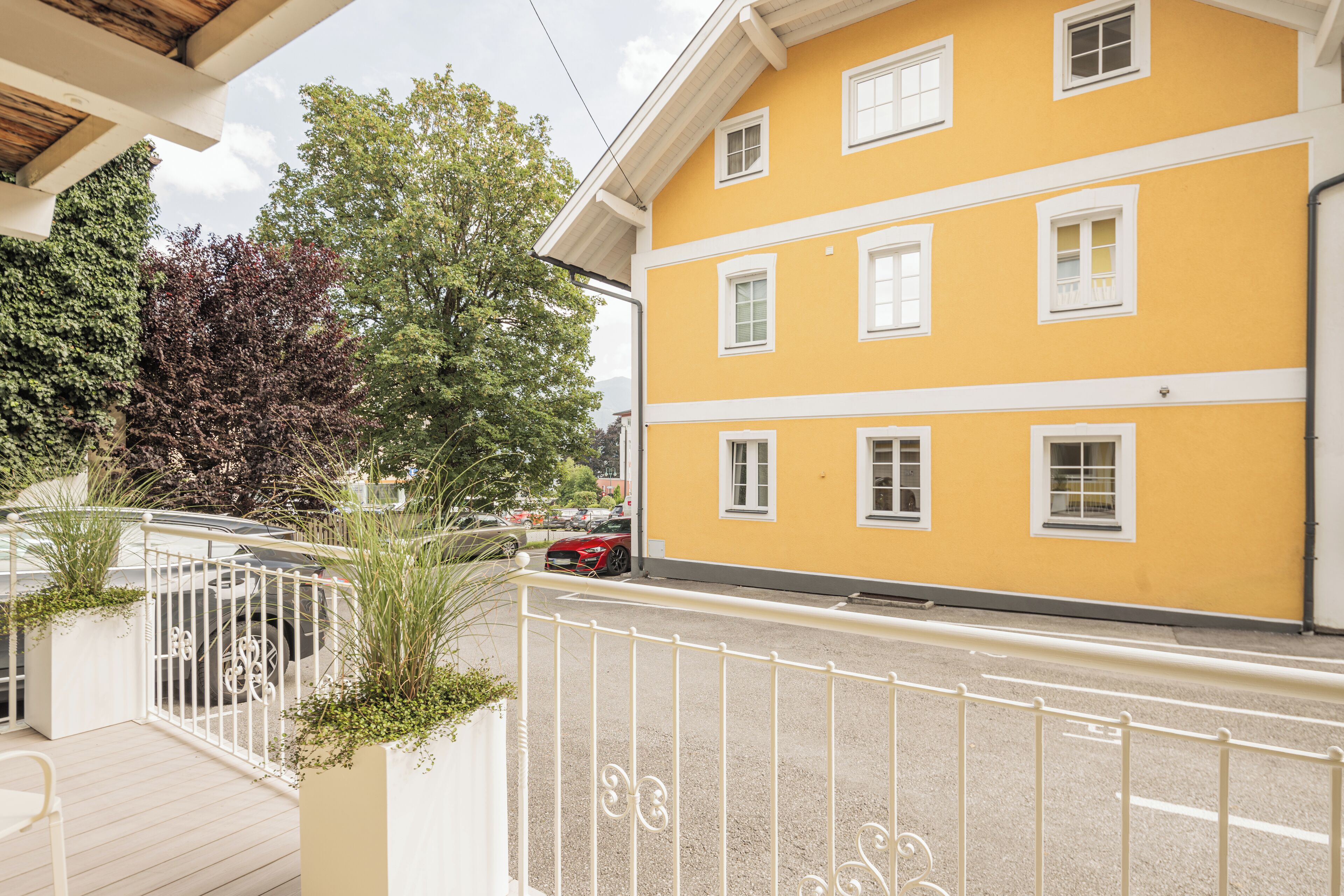 Ein gelbes Gebäude mit weißen Verzierungen und vielen Fenstern.