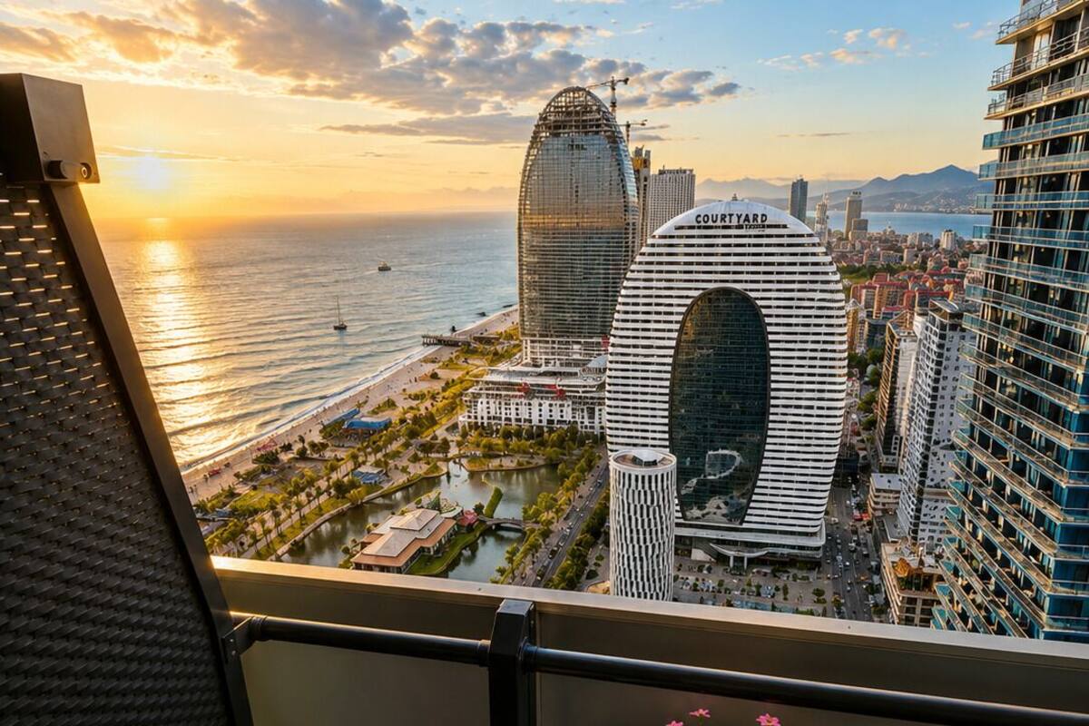 Un balcon offrant une vue sur le paysage urbain, avec notamment un bâtiment remarquable portant l’inscription « COURTYARD ».