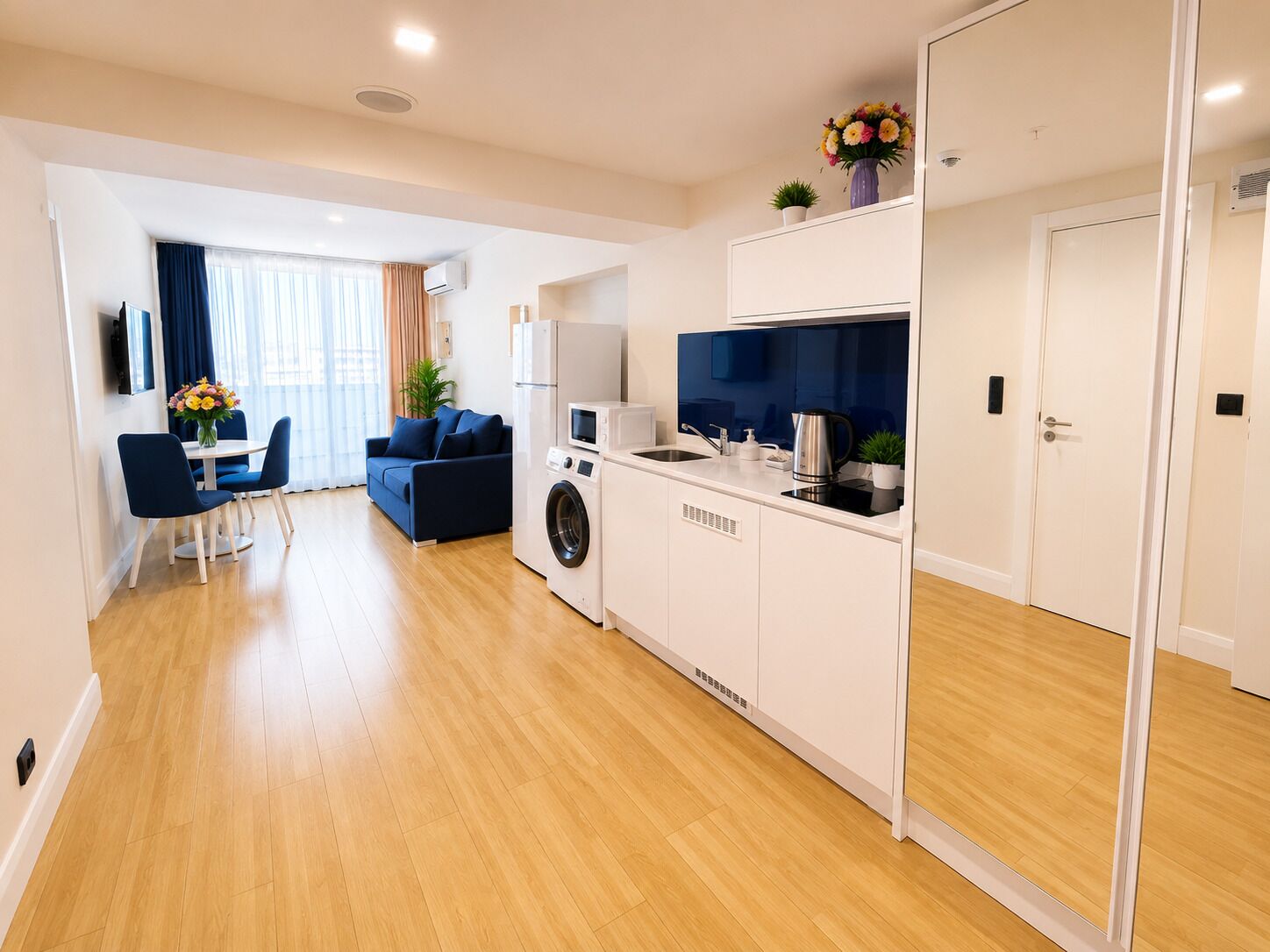 A modern apartment with a kitchen, dining area, and a living room.