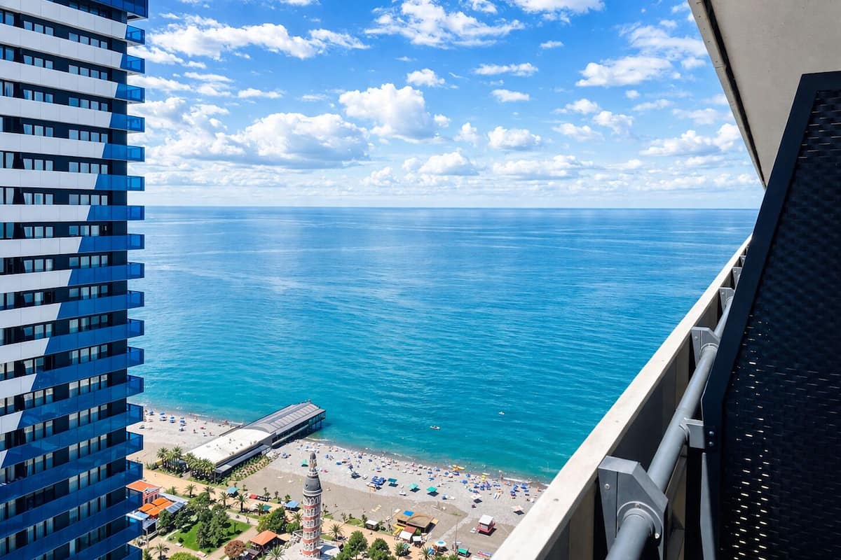 Un immeuble de grande hauteur offrant une vue sur une plage et la mer.