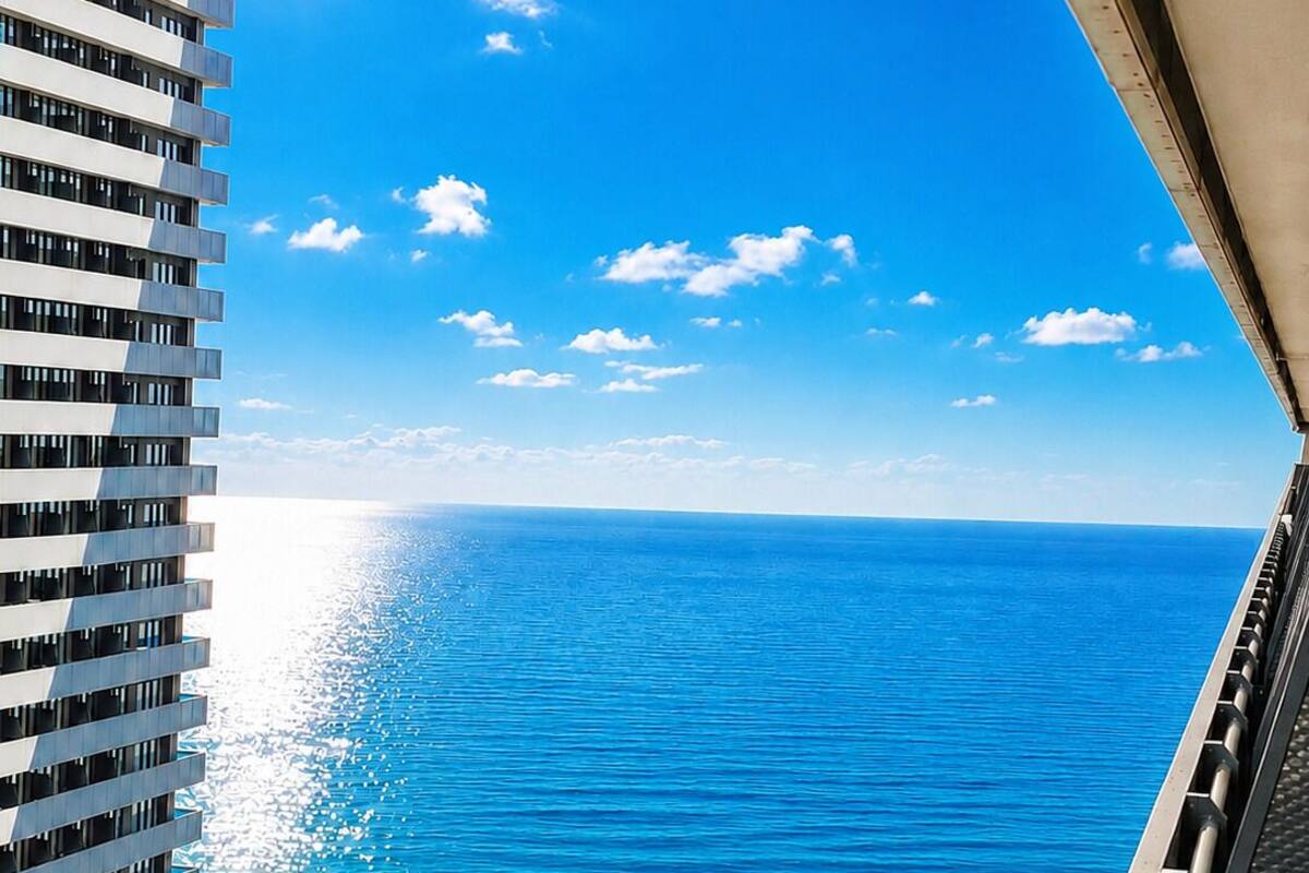 Un immeuble de grande hauteur offrant une vue sur l’océan et la plage.