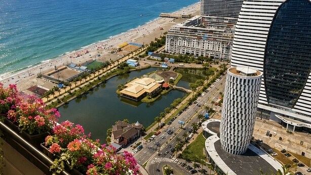 A coastal hotel with a modern design, featuring a prominent curved building and a circular structure. - Orbi City Sea View (Batumi)