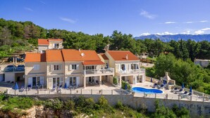 A multi-story building with a swimming pool, outdoor seating, and a view of mountains. - Stunning home in Sumartin with WiFi (Sumartin)