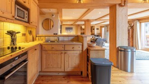 Une cuisine en bois équipée d’un four, d’un micro-ondes et d’un évier intégrés.