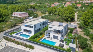 A modern two-story building with a rooftop pool and outdoor seating area. - Pet friendly home in Orebic with sauna (Orebic)