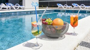 A poolside setting with lounge chairs, a fruit bowl, and two drinks. - Pet friendly home in Orebic with sauna (Orebic)