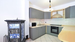 A kitchen with grey cabinets, a microwave, a sink, and a stove.
