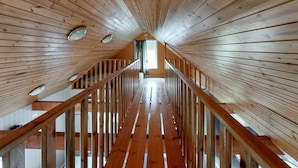 Eine Holztreppe mit Blick auf ein Fenster im Obergeschoss.