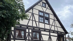 A traditional half-timbered house with multiple windows, a visible fire hydrant, and a paved pathway. - old town residence (Weißenhorn)