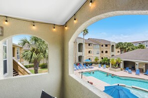 A pool area with lounge chairs and umbrellas, a staircase, and a view of neighboring buildings. - POOL VIEW! Newly renovated, free parking,  free WI-FI (Clearwater)