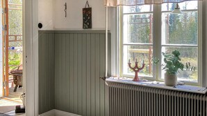 A room with a radiator, a window with a view of greenery, and a door leading outside. - 2 bedroom stunning home in Nås (Nås)