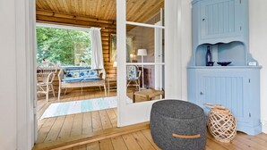 A cozy room with a wooden floor, a grey ottoman, a wicker basket, and a blue cabinet. - 3 bedroom amazing home in Gilleleje (Gilleleje)