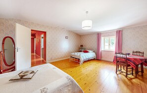 Une chambre à coucher avec un lit, une table, une chaise, une fenêtre et une porte.