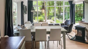 Un comedor con una mesa grande, sillas y una chimenea.
