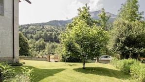 A house with a well-maintained lawn and a tree in the foreground. - Watering Can And Soldier (PLANAY)