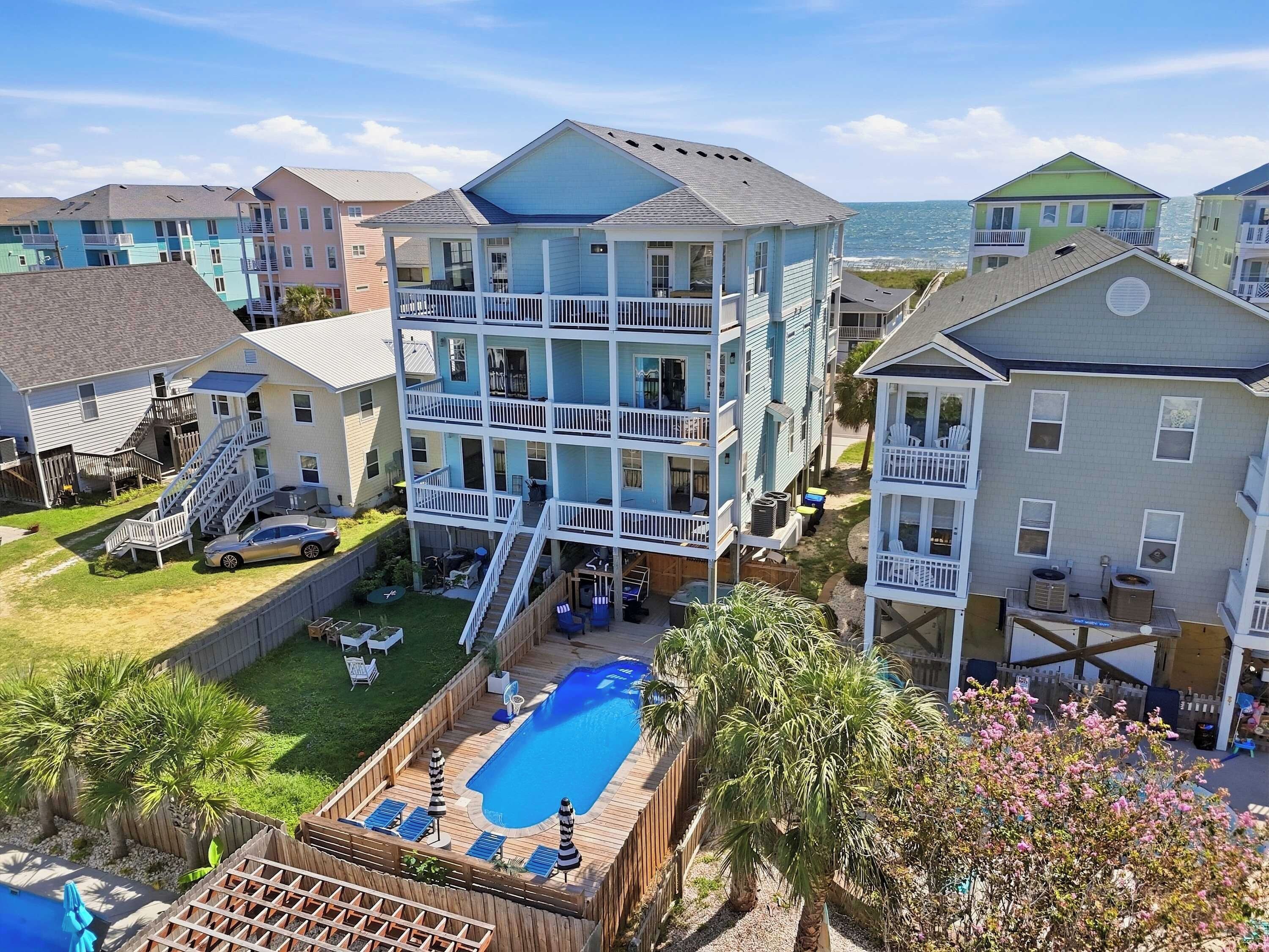 A multi-story residential building with a pool and outdoor seating area.