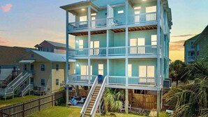 A multi-story building with balconies, a staircase, and a fenced yard. - Ocean Views-Private Heated Pool & Hot Tub-3 Kings! (Carolina Beach)