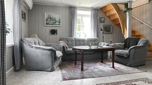 A living room with a sofa set, a coffee table, and a staircase.