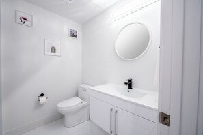 Une salle de bain moderne avec des toilettes, un lavabo et un miroir.