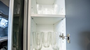 A cabinet with multiple clear glass tumblers and a single clear glass. - Cozy 1BR with Parking, Only 7 Mins to The Falls and Sleeps 3! (Niagara Falls)