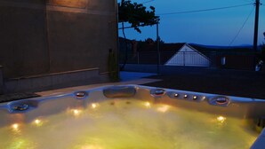 A hot tub with a stone wall and a metal fence in the background. - 2 bedroom lovely home in Grizane (Grizane)