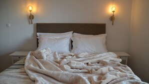 A bed with a headboard, two bedside tables, and wall-mounted lamps. - 2 bedroom lovely home in Grizane (Grizane)
