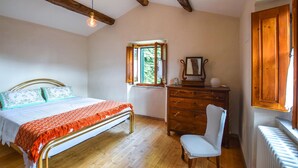 A bedroom with a bed, a dresser, a chair, a window, and a radiator. - 3 bedroom pet friendly home in Barga (Barga)