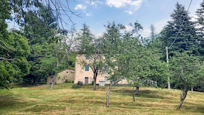 A building with a stone facade and a flat roof, surrounded by trees and grass. - 3 bedroom pet friendly home in Barga (Barga)