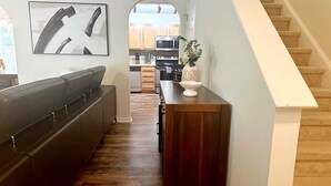 Une cuisine moderne avec des meubles en bois, un four à micro-ondes et un coin repas équipé d’une banquette.