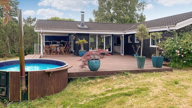 Een huis met een overdekte patio, een zwembad en potplanten.