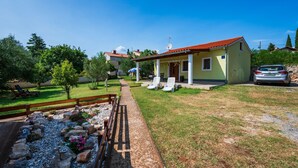 A small, single-story building with a red-tiled roof, a covered porch, and a gravel pathway leading to it. - Stunning home in Medulin with WiFi (Medulin)
