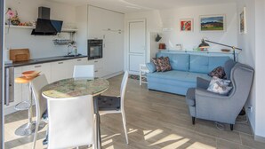 A compact living space with a kitchenette, a dining area, and a seating area with a sofa and chairs. - Beautiful home in Dobrenici with sauna (Dobrenici)
