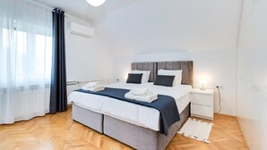 Une chambre à coucher moderne avec un lit, des tables de chevet, une lampe et un radiateur.