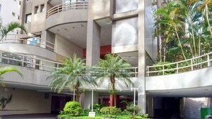 A multi-level building with a central courtyard featuring palm trees and a small garden.