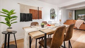 A modern dining area with a wooden table, brown chairs, and a potted plant.