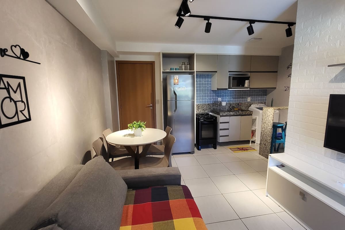 A compact living space with a kitchenette, a dining area, and a sofa.
