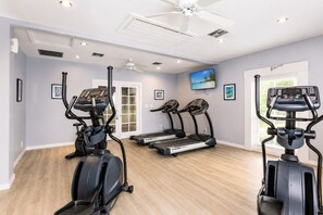 Ein Heimfitnessraum mit Laufbändern, einem Crosstrainer und einem stationären Fahrrad.
