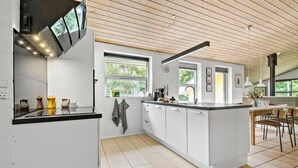 A modern kitchen with a central island, white cabinetry, and a wooden ceiling. - Lovely home in Glesborg with sauna (Glesborg)