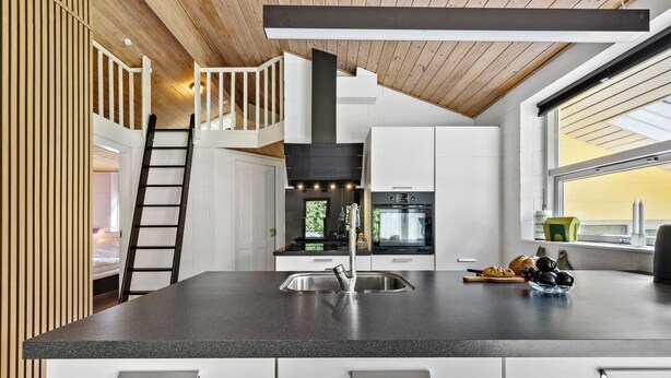 A modern kitchen with a central island, a built-in oven, and a large window. - Lovely home in Glesborg with sauna (Glesborg)